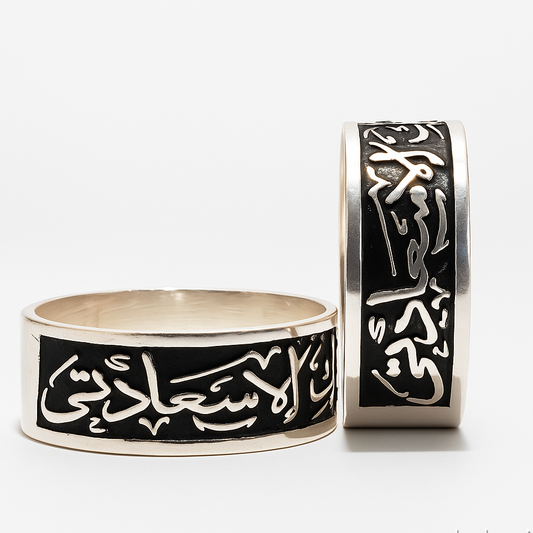 Two silver rings with Arabic calligraphy on a white background