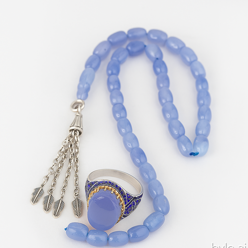 Blue beaded necklace with a silver pendant and ring on a white background