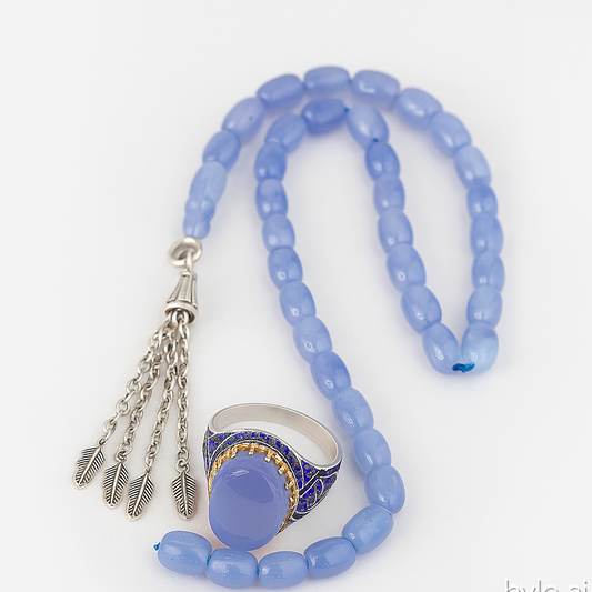 Blue beaded necklace with a silver pendant and ring on a white background
